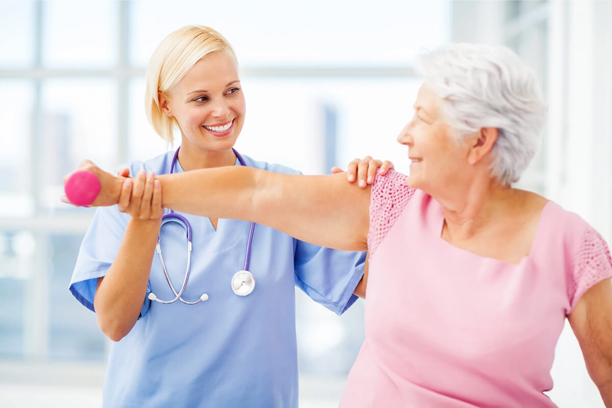 Пожилая женщина держит гантелю на вытянутой руке у врача-кардиолога